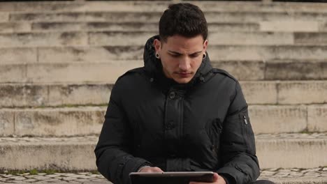 Focused-young-man-using-tablet-outdoor